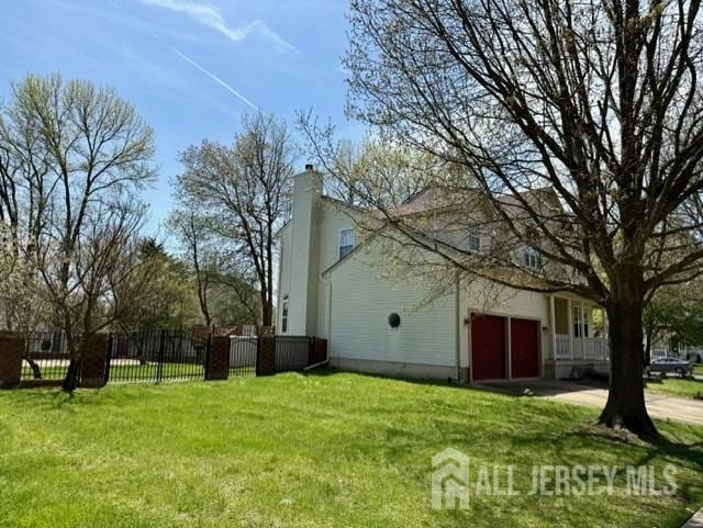 view of property exterior featuring fence, a chimney, a yard, and a garage