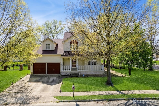 traditional home featuring a garage, driveway, a front lawn, and covered porch