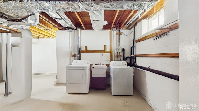 washroom featuring washing machine and clothes dryer, a sink, and laundry area