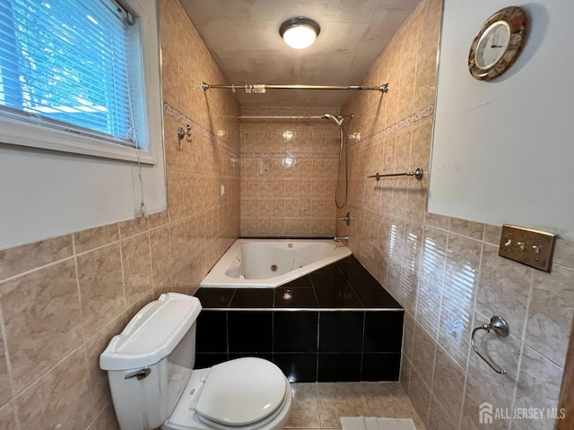 bathroom with toilet, tile walls, and tiled shower / bath