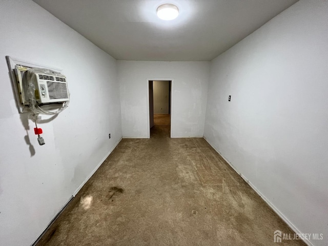 carpeted spare room featuring a wall mounted air conditioner