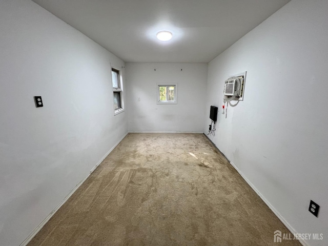 unfurnished room with light colored carpet and a wall mounted AC