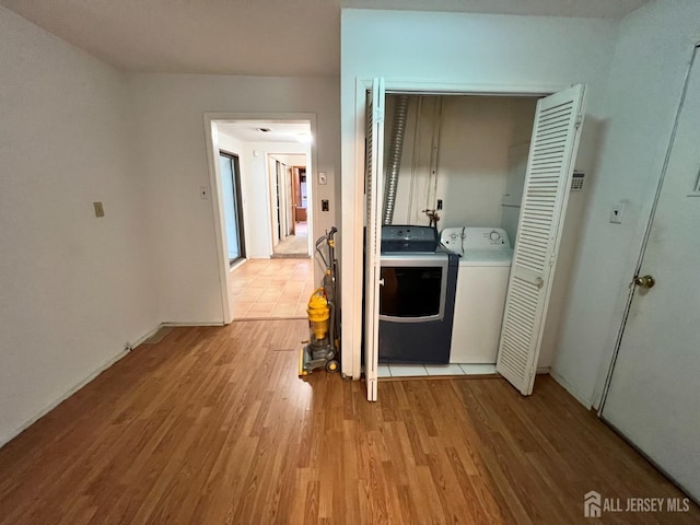 washroom with light hardwood / wood-style flooring and washer and clothes dryer