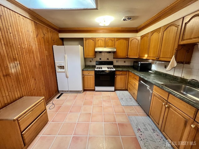 kitchen with white refrigerator with ice dispenser, gas range oven, stainless steel dishwasher, light tile patterned floors, and sink