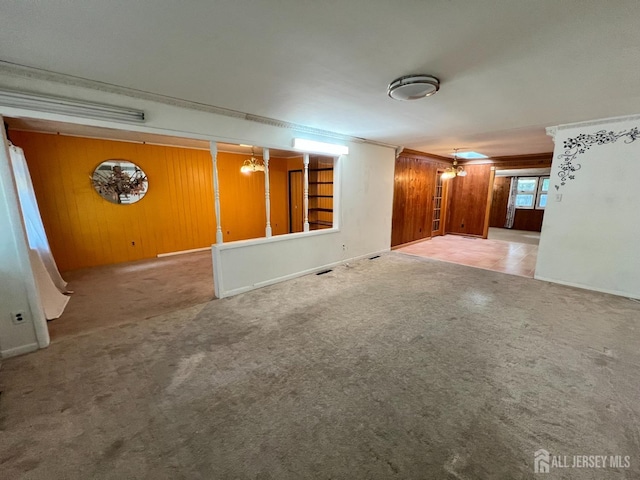 unfurnished room with carpet floors and wooden walls