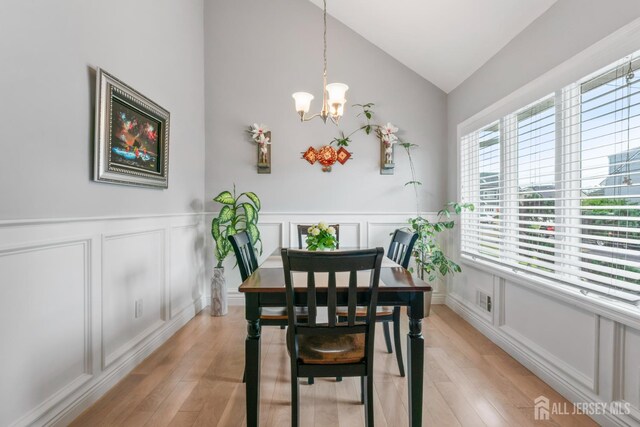 21 Haug St, Union Beach, NJ 07735 - dining space with a decorative wall, lofted ceiling, a chandelier, light wood-style floors, and a wainscoted wall