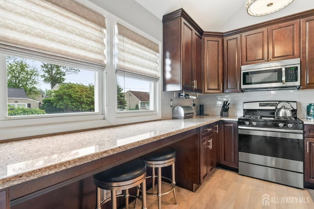 21 Haug St, Union Beach, NJ 07735 - kitchen with appliances with stainless steel finishes, light stone countertops, backsplash, light wood-type flooring, and lofted ceiling