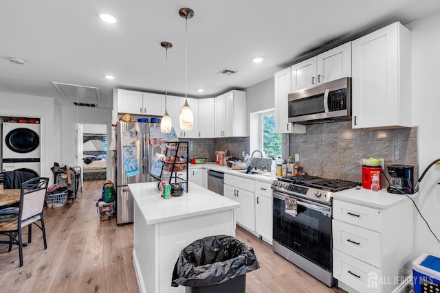 176 Main St, East Brunswick, NJ 08816 - kitchen with appliances with stainless steel finishes, estacked washer and dryer, a center island, light countertops, and recessed lighting