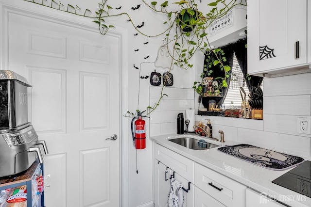 176 Main St, East Brunswick, NJ 08816 - kitchen with decorative backsplash, white cabinetry, and light stone counters