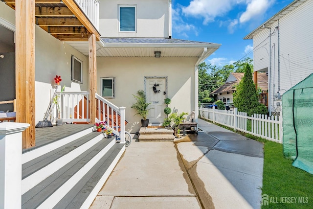 176 Main St, East Brunswick, NJ 08816 - view of exterior entry with stucco siding and roof with shingles