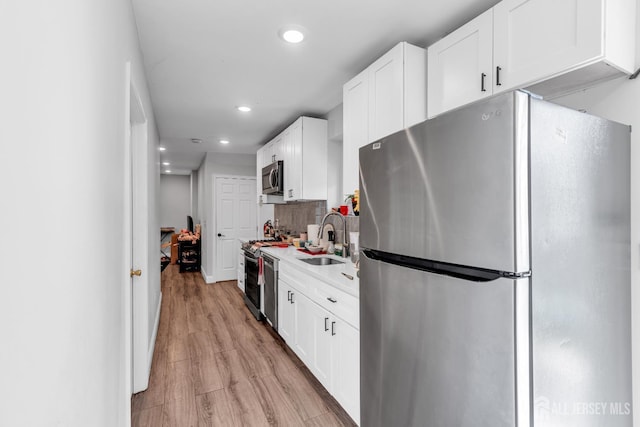 176 Main St, East Brunswick, NJ 08816 - kitchen with stainless steel appliances, light wood-style flooring, recessed lighting, white cabinets, and light countertops