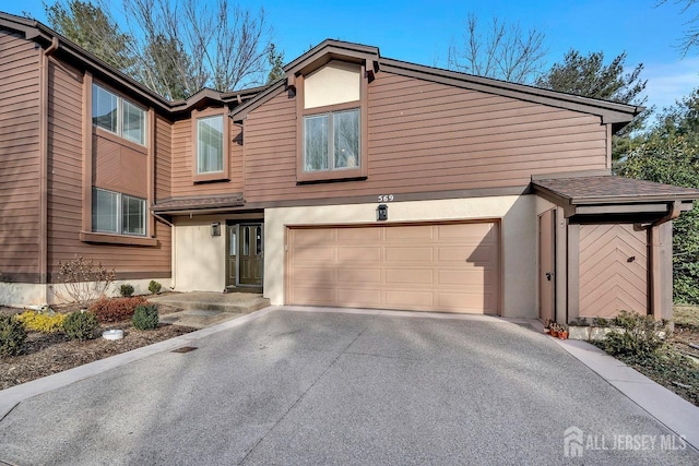 569 Sayre Dr, Plainsboro, NJ 08540 - view of front of home featuring driveway, a garage, and stucco siding
