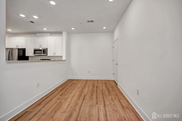 unfurnished living room with baseboards, visible vents, and recessed lighting