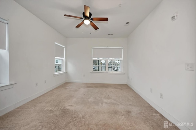 unfurnished room featuring baseboards, ceiling fan, visible vents, and carpet flooring