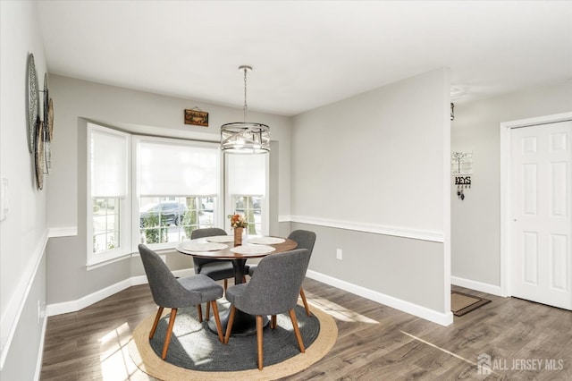 dining room with dark hardwood / wood-style floors and a notable chandelier