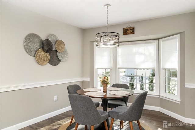 dining space featuring dark hardwood / wood-style flooring and a chandelier