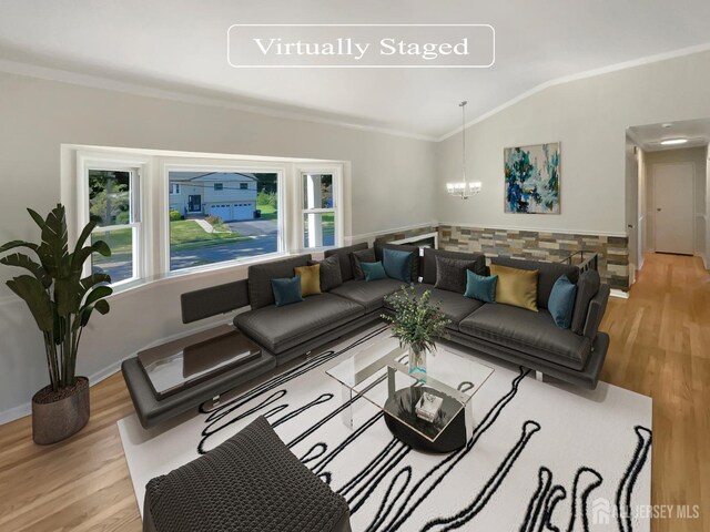 living room featuring crown molding, light hardwood / wood-style floors, vaulted ceiling, and a notable chandelier