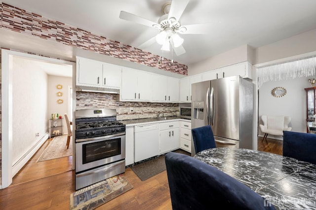 21 Coolidge Ave, East Brunswick, NJ 08816 - kitchen with stainless steel appliances, baseboard heating, a ceiling fan, backsplash, and white cabinetry