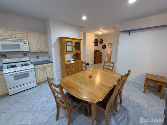 dining area featuring light tile patterned flooring and recessed lighting