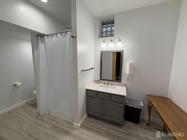 full bathroom featuring wood finished floors, toilet, vanity, baseboards, and a shower with curtain