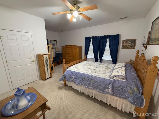 bedroom featuring light carpet and a ceiling fan