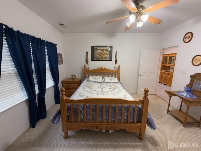 bedroom with light colored carpet, a ceiling fan, and baseboards