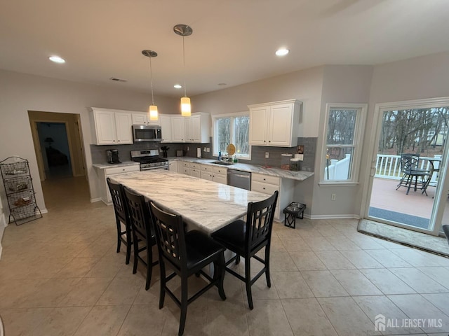 kitchen with stainless steel appliances, light tile patterned flooring, white cabinets, and recessed lighting