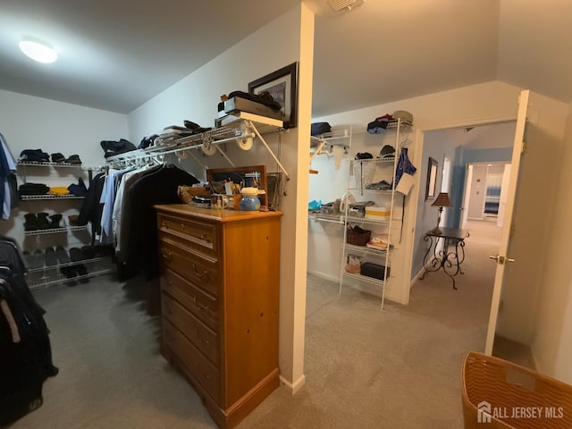 walk in closet featuring carpet flooring and vaulted ceiling