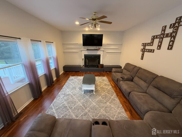 living room featuring dark wood-type flooring and ceiling fan