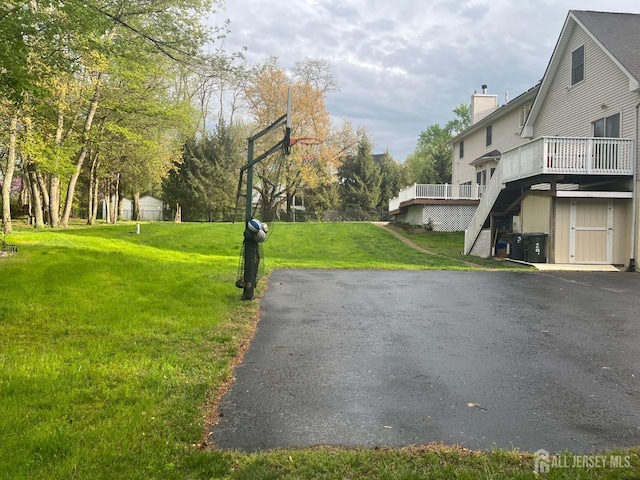view of asphalt driveway with stairway