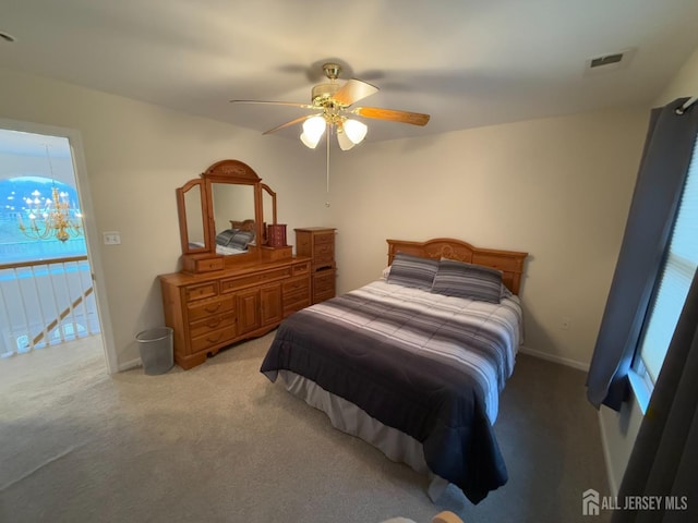 bedroom featuring light carpet, a chandelier, ceiling fan, and baseboards