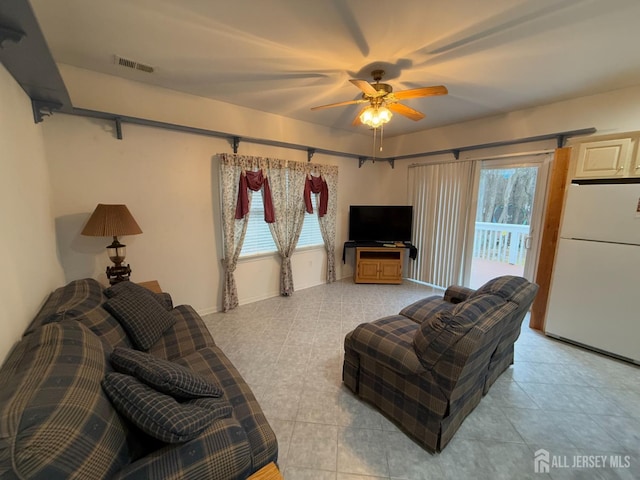 tiled living room featuring ceiling fan