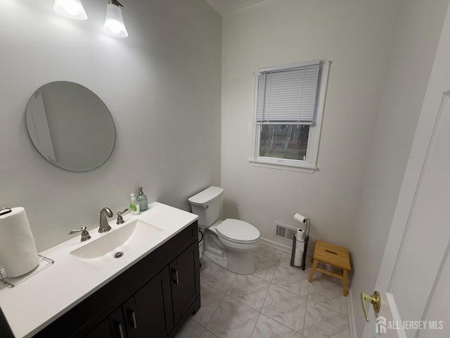 half bath featuring marble finish floors, toilet, and vanity