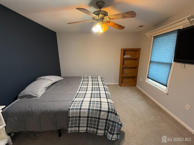 carpeted bedroom with ceiling fan and baseboards
