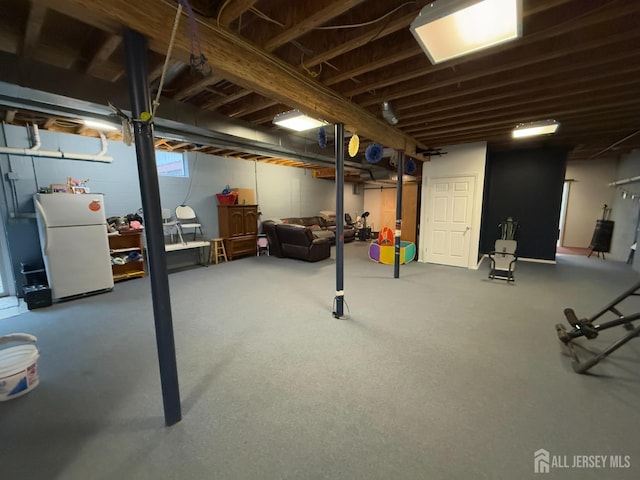 below grade area featuring freestanding refrigerator
