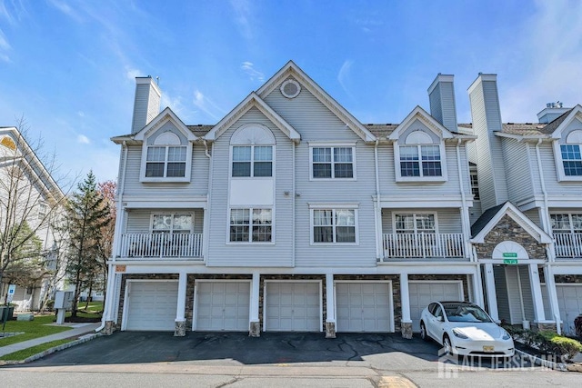 46 Prestwick Way, Edison, NJ 08820 - view of property featuring a chimney, driveway, an attached garage, and stone siding
