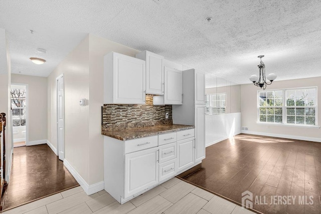 46 Prestwick Way, Edison, NJ 08820 - kitchen featuring baseboards, light wood-style floors, a chandelier, tasteful backsplash, and a textured ceiling