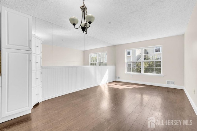 46 Prestwick Way, Edison, NJ 08820 - unfurnished dining area with a textured ceiling, dark wood finished floors, and baseboards