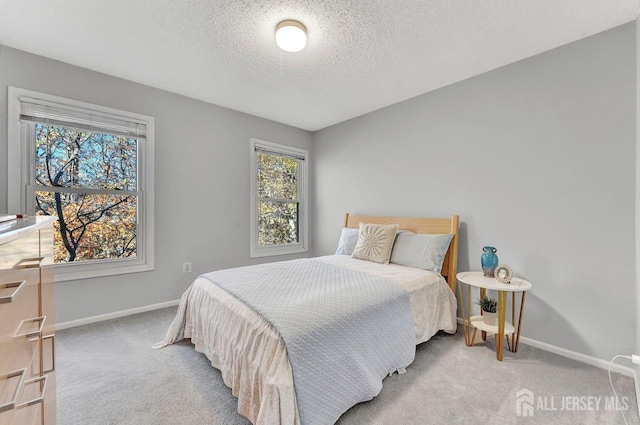 bedroom with a textured ceiling and light colored carpet