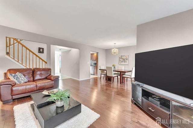 living room featuring wood-type flooring and an inviting chandelier