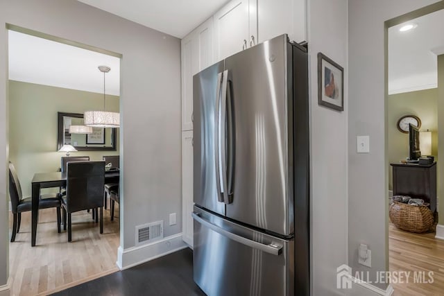 117 Osceola Ave, Middlesex, NJ 08846 - kitchen with freestanding refrigerator, white cabinets, wood finished floors, and a chandelier