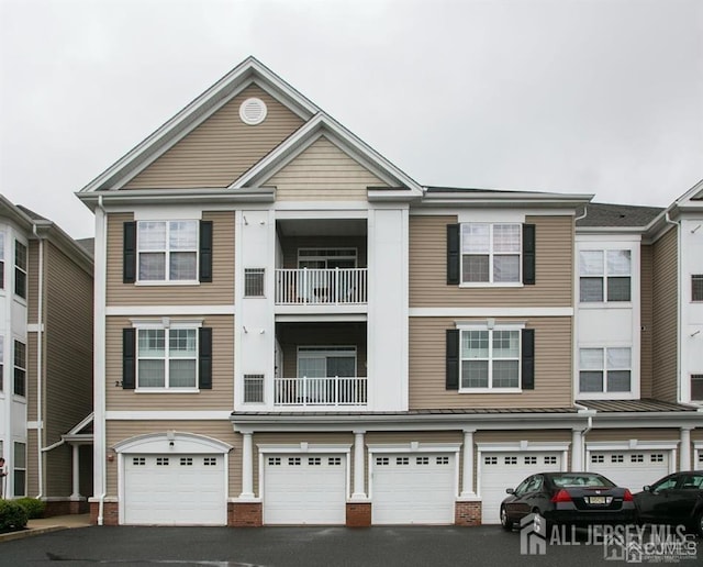 townhome / multi-family property featuring brick siding, driveway, and an attached garage