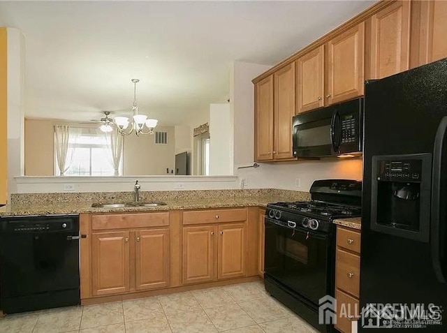 kitchen with a notable chandelier, a sink, visible vents, light stone countertops, and black appliances