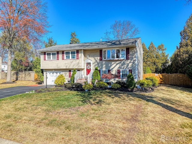 split foyer home featuring a garage and a front lawn