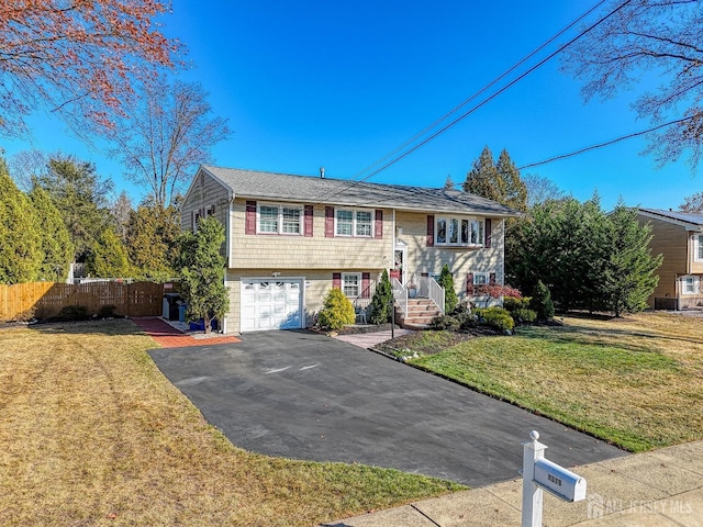 raised ranch with a garage and a front lawn