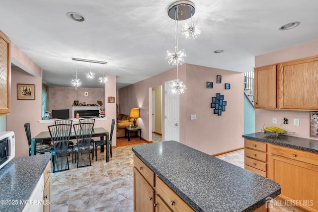 11 Patio Ct, Monroe, NJ 08831 - kitchen with dark countertops, a chandelier, open floor plan, a kitchen island, and a fireplace