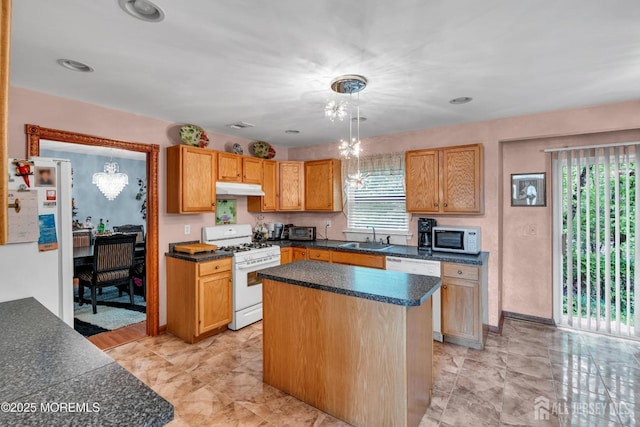11 Patio Ct, Monroe, NJ 08831 - kitchen with white appliances, a sink, under cabinet range hood, dark countertops, and a center island