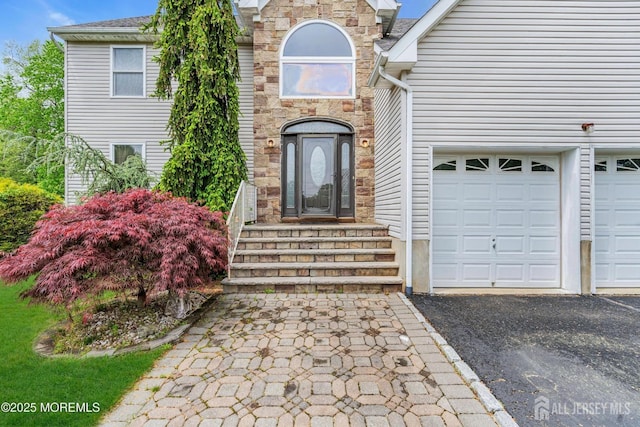 11 Patio Ct, Monroe, NJ 08831 - entrance to property featuring a garage, driveway, and stone siding