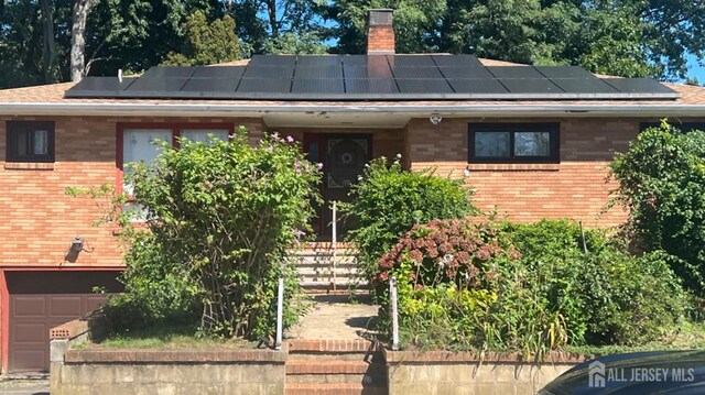 view of front facade with solar panels and a garage