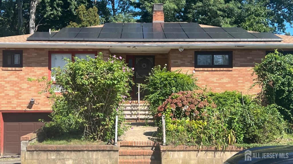 view of front of home with a chimney and brick siding